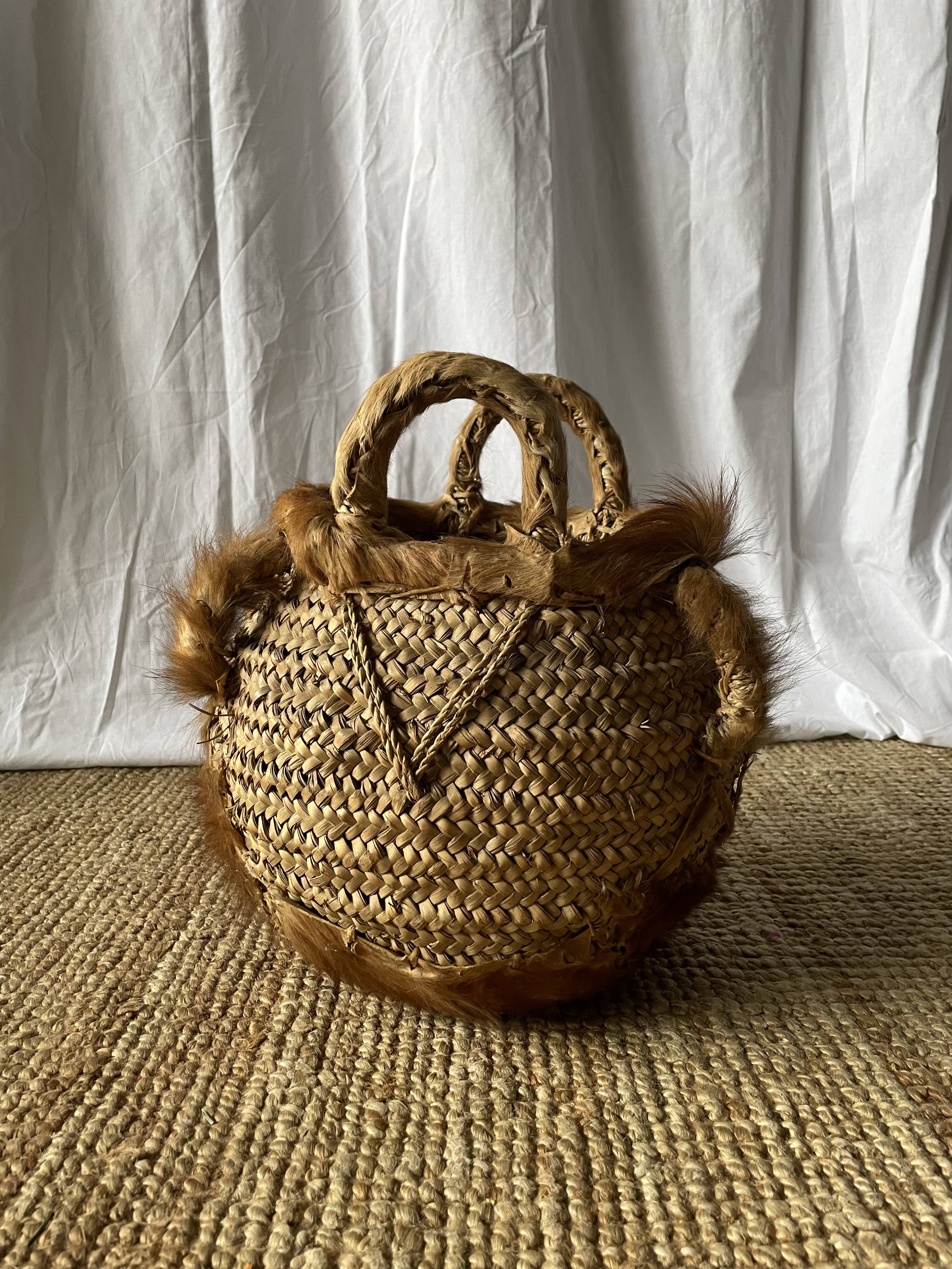Handwoven vintage basket with handles made from natural fibres.