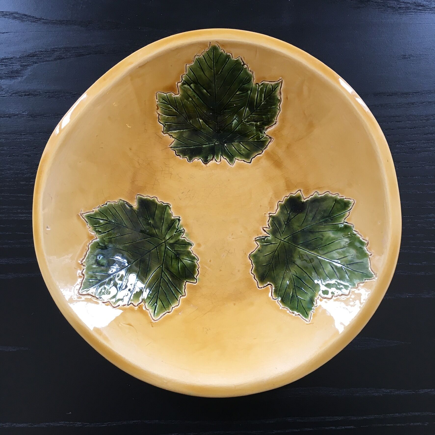 Plate signed with green leaf decoration.