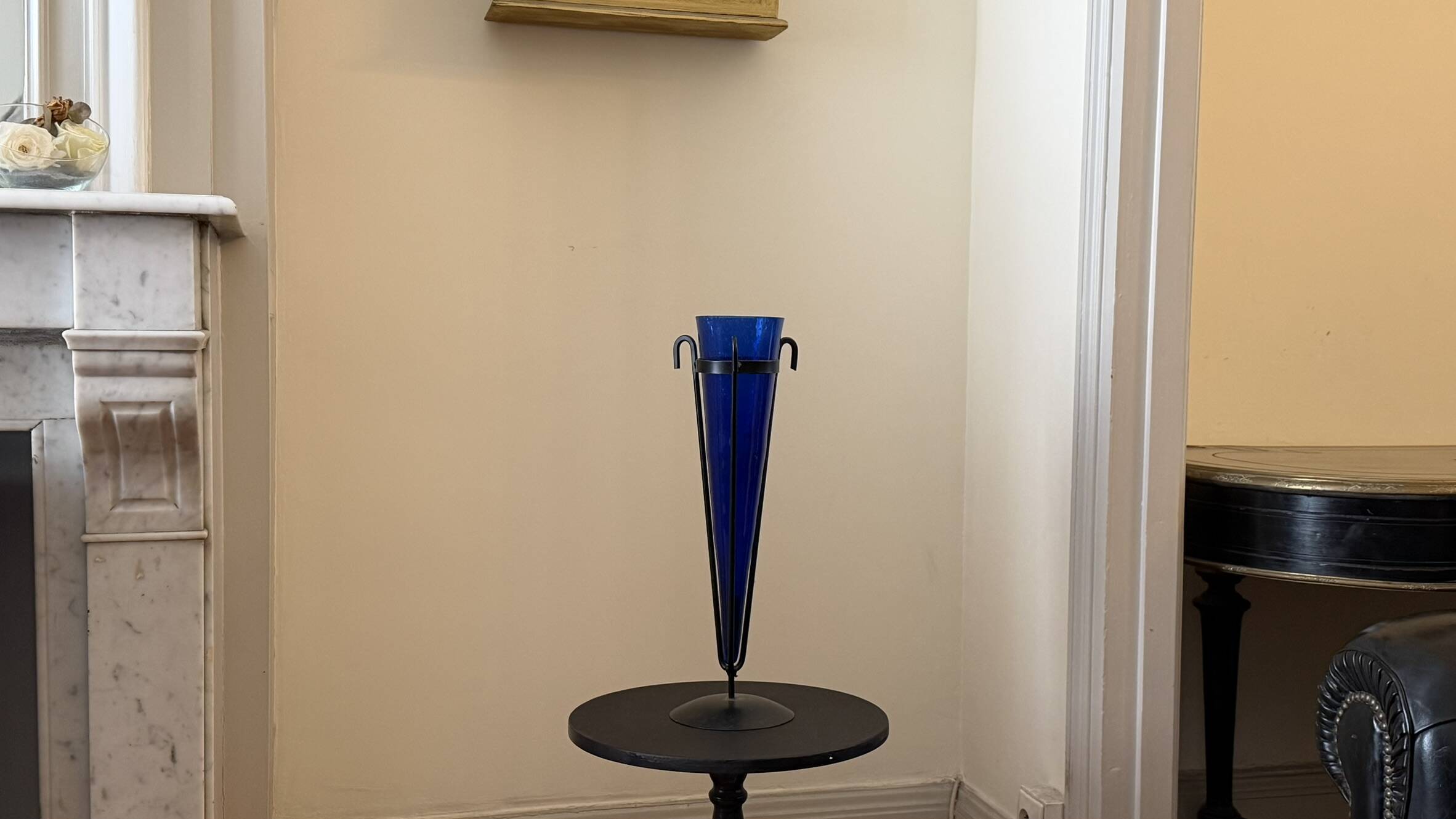 Cobalt blue vase on a metal structure.