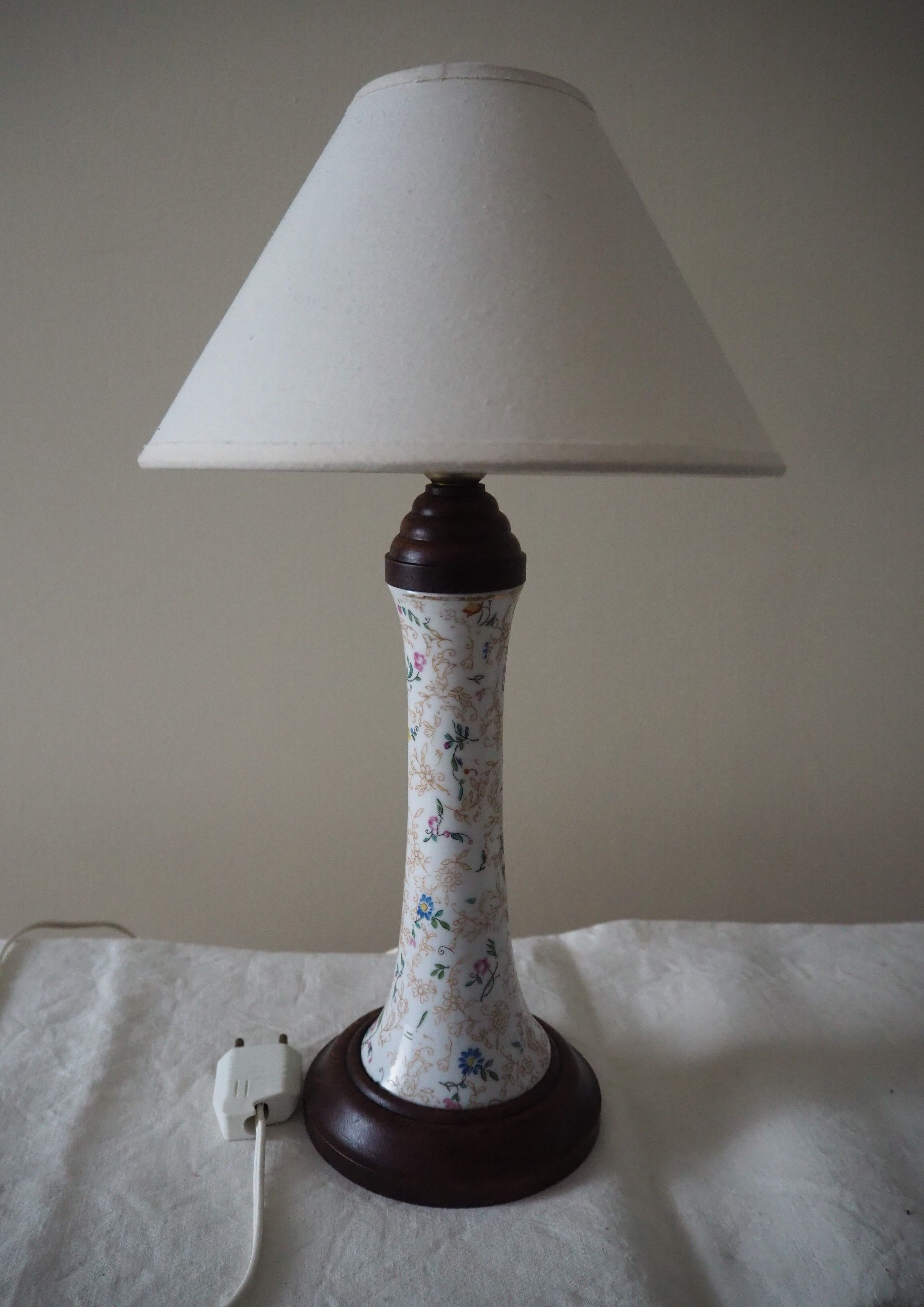 Table lamp for bedside use in earthenware with a wooden base.