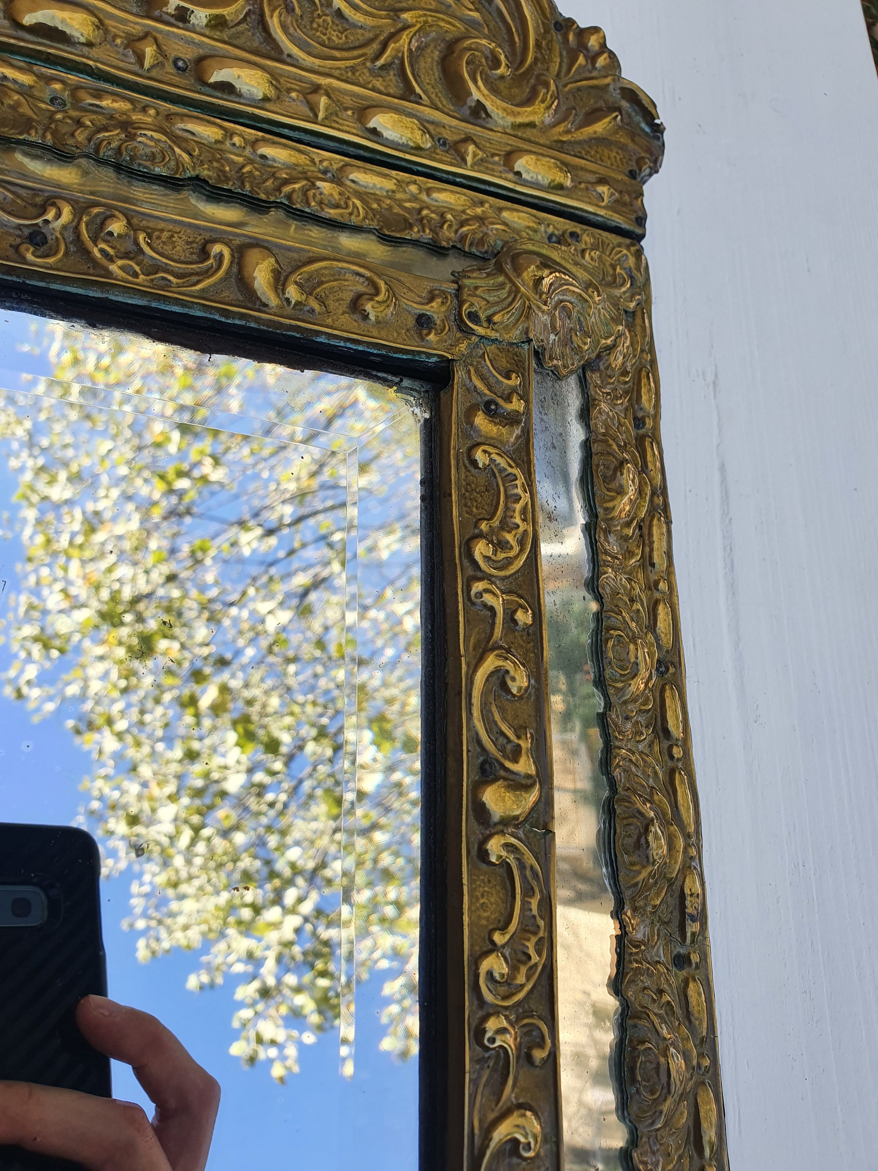 Miroir à parecloses en bois doré et métal repoussé