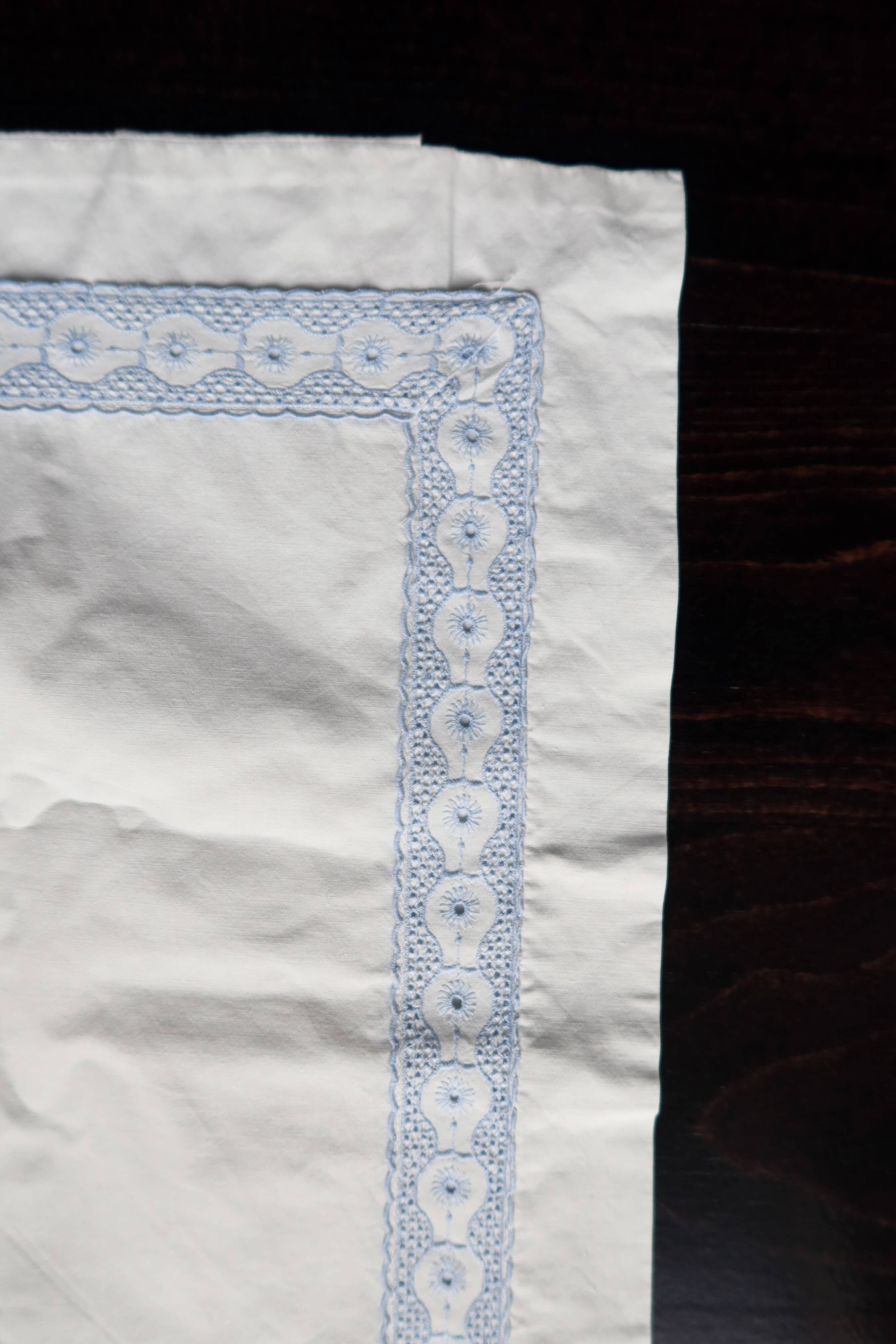Vintage embroidered pillowcase with light blue thread.