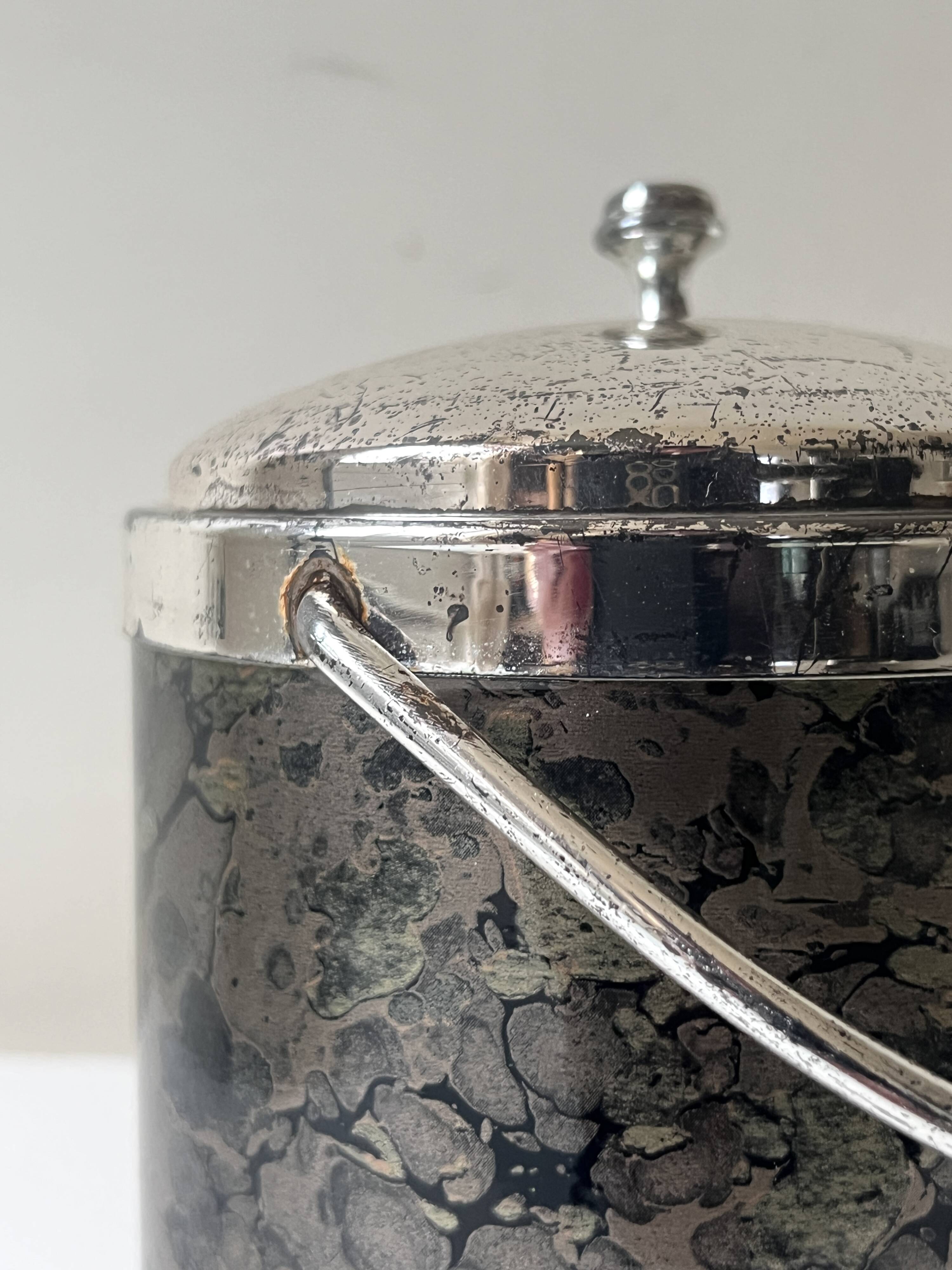 Vintage chrome metal ice bucket with black marbled design, 1970s style.