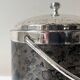 Vintage chrome metal ice bucket with black marbled design, 1970s style.