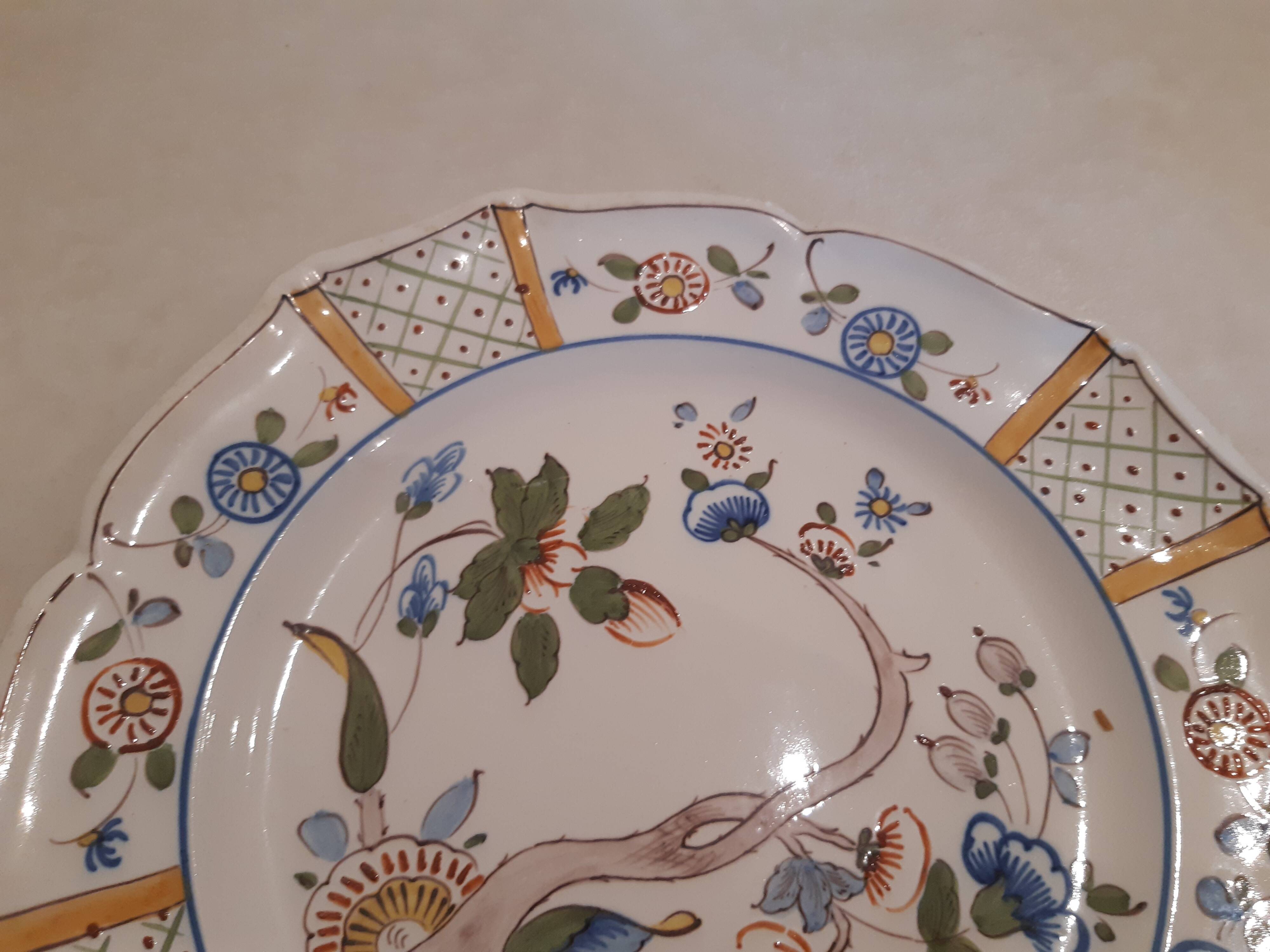 Flat plate in earthenware, hand-painted rural decoration partly in relief,
