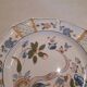 Flat plate in earthenware, hand-painted rural decoration partly in relief,