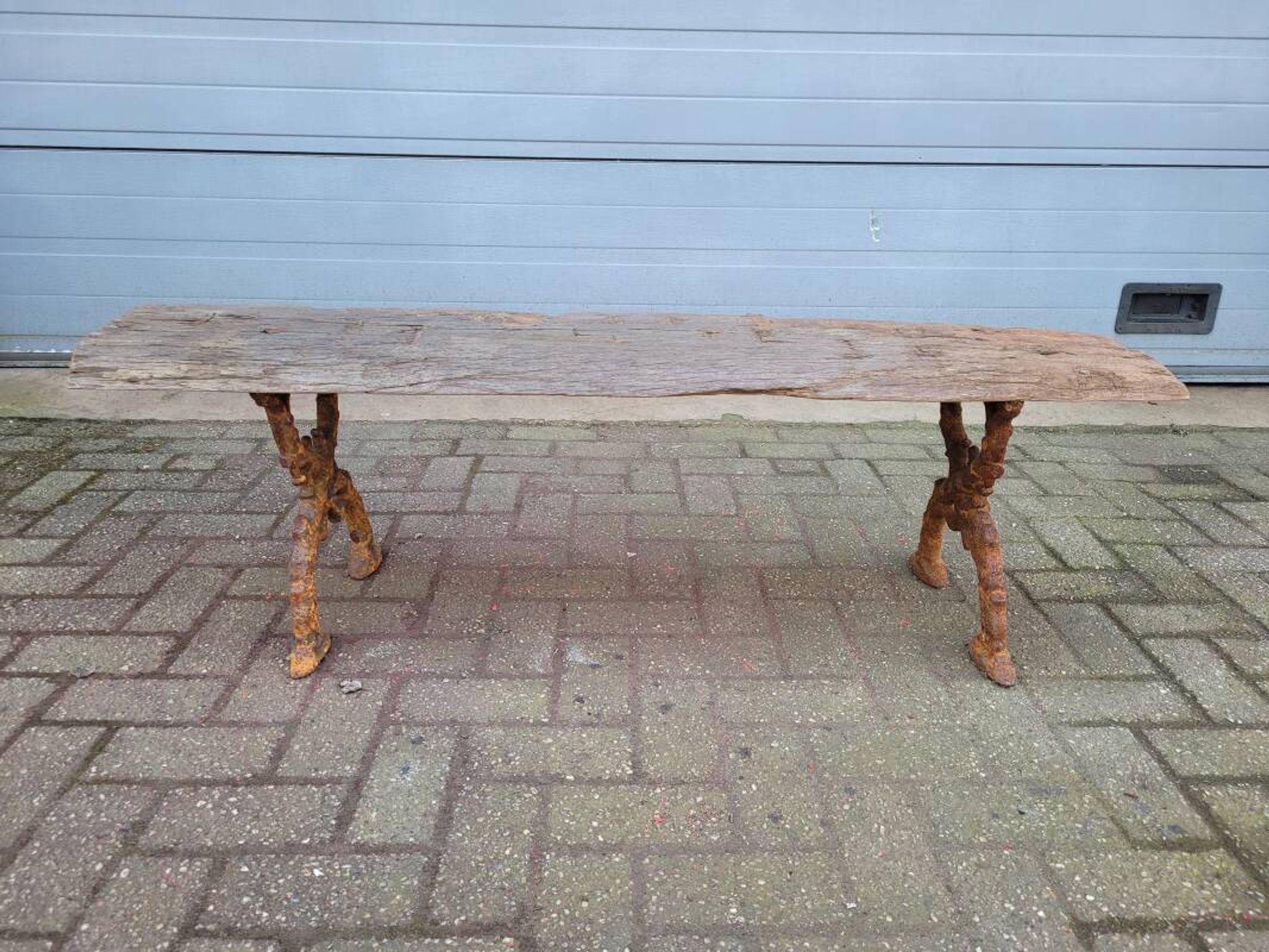 French country style cast iron bench with old rustic wooden plank