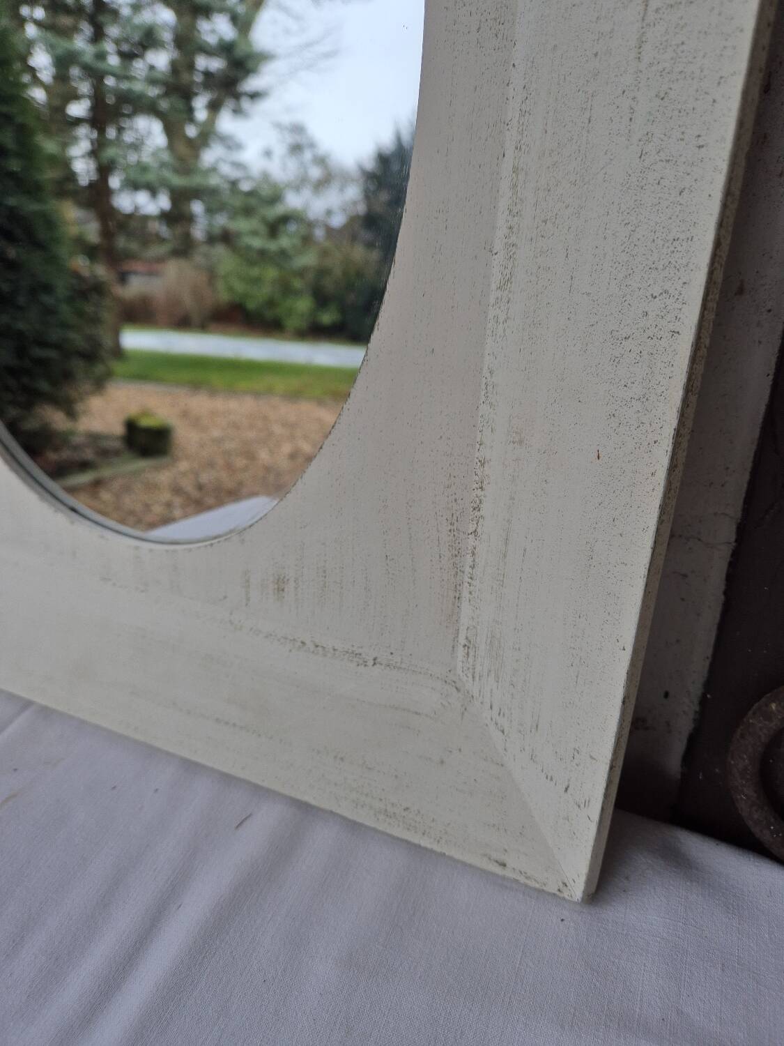 Oval mirror with a distressed white frame