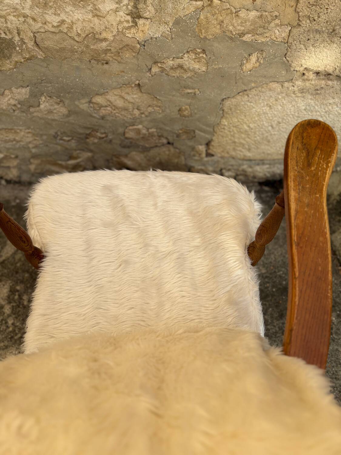 Scandinavian armchair in solid wood with beige fur cushion