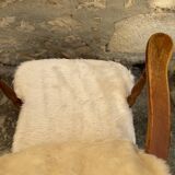 Scandinavian armchair in solid wood with beige fur cushion