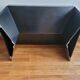 Minimalist/industrial coffee table with a black metal frame and a grey fabric top.