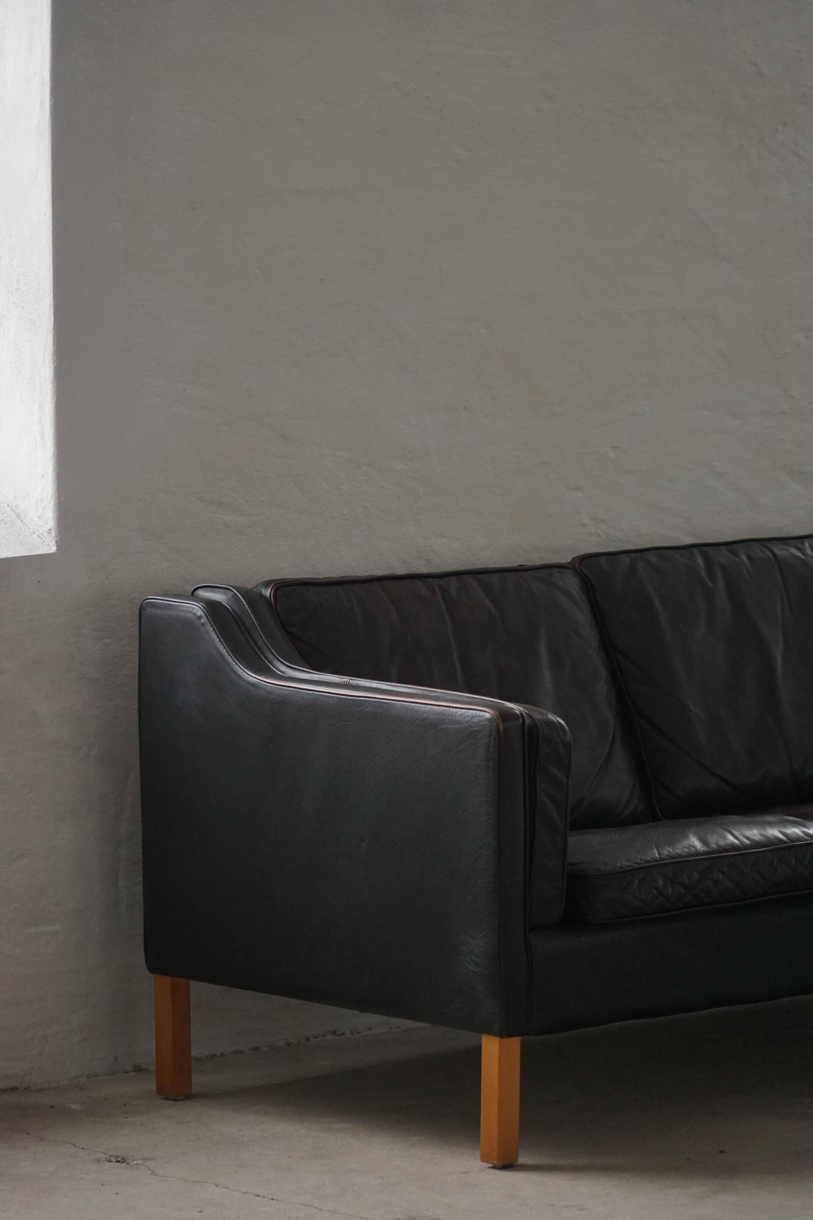 Three-seater canapé by Mogens Hansen, mid-century, in patinated black leather and solid beech.