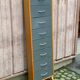 Scandinavian shoe storage cabinet in grey wood and metal.