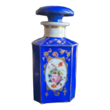 Perfume bottle in porcelain of old paris blue background