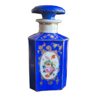 Perfume bottle in porcelain of old paris blue background