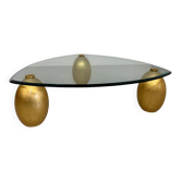 Large sculptural coffee table in glass and gold wood, 1980s design.
