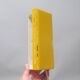 Modernist wall light with a yellow pivoting shade from the 1980s.