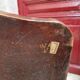 Antique club chair in patinated brown leather, early 20th century English style.