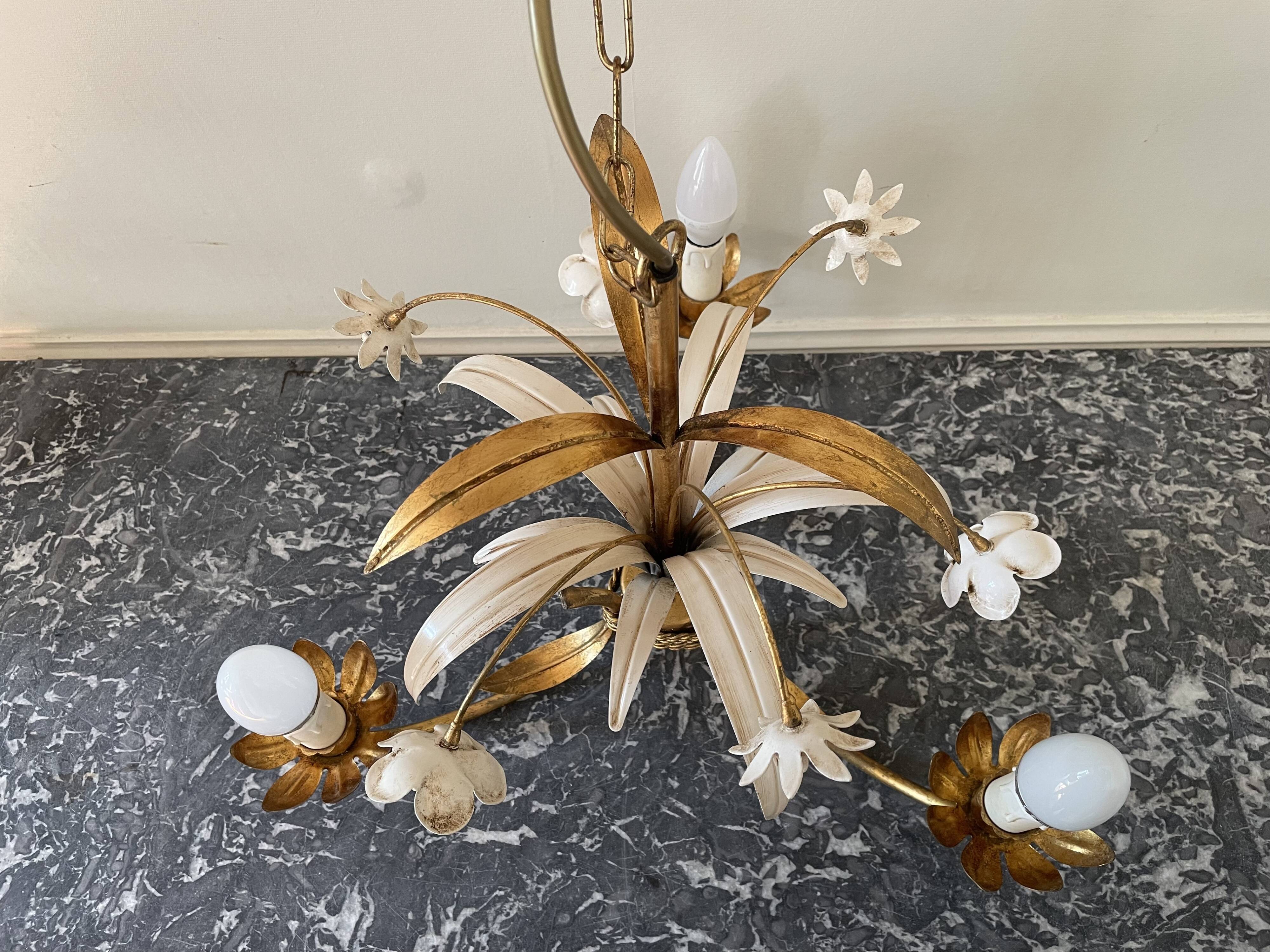 Golden metal chandelier decorated with flowers