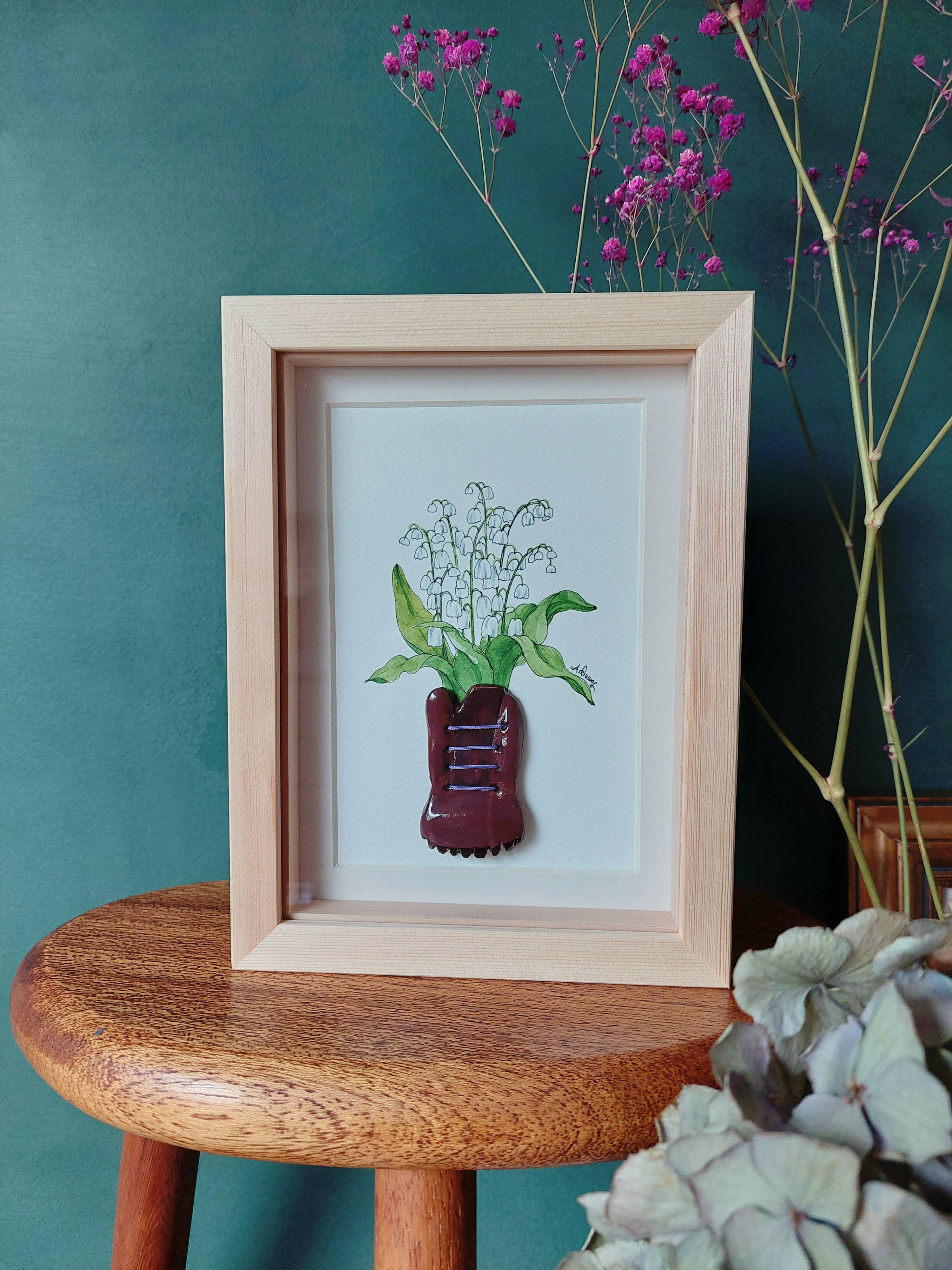 Composition of a bouquet of lilies of the valley in a shoe-shaped clay pot
