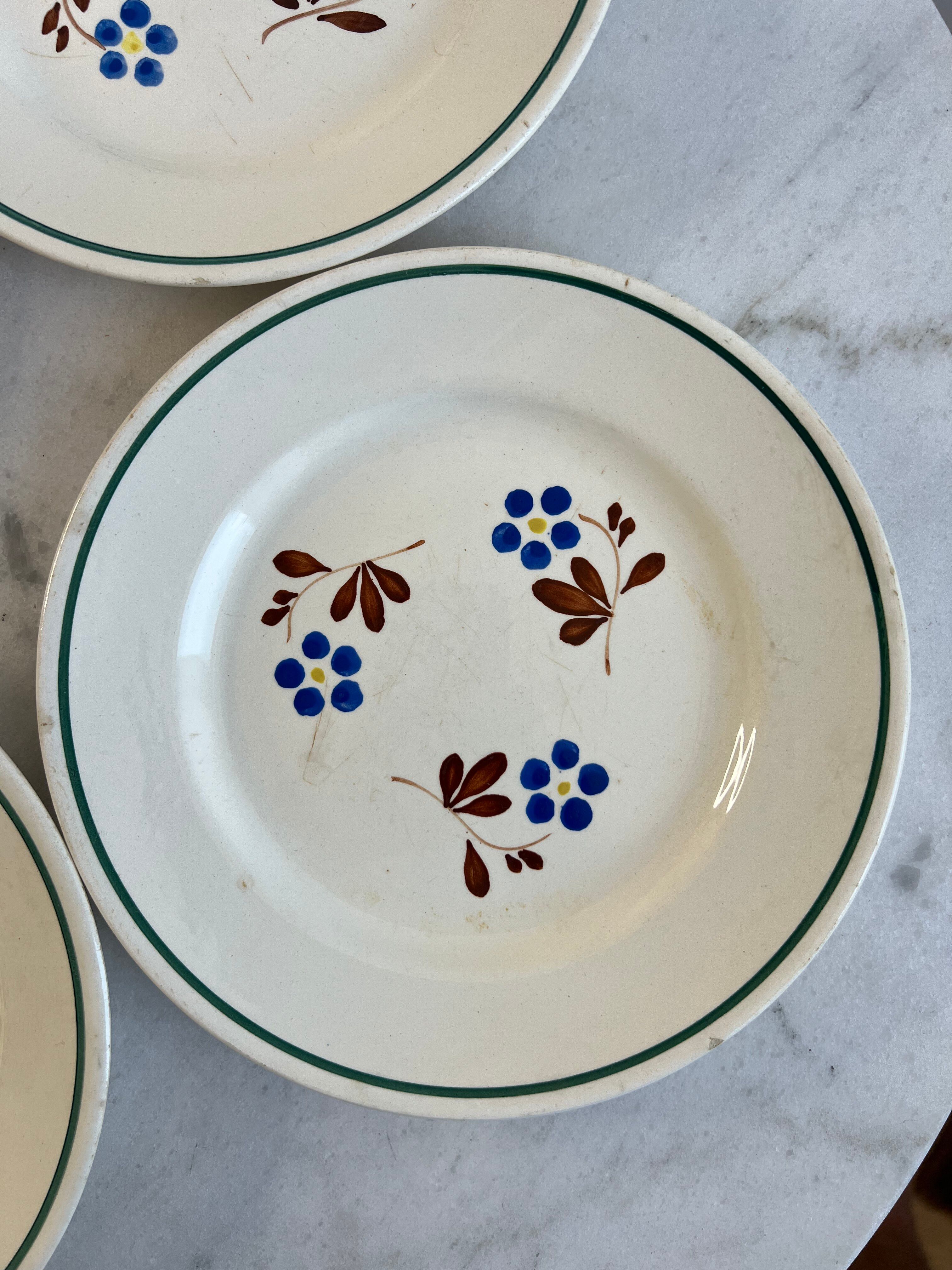 Set of 4 small flat plates with floral designs.