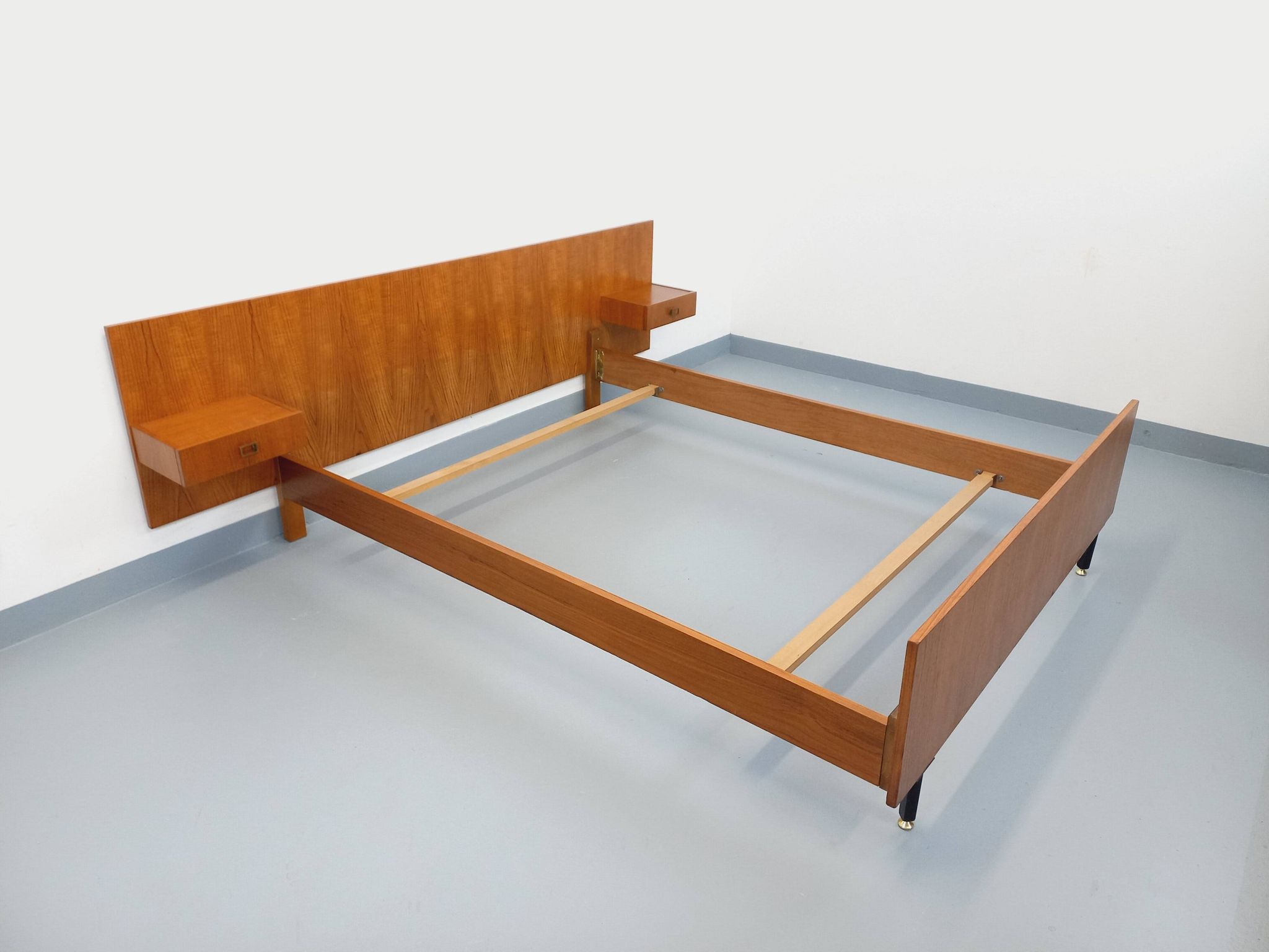 Double bed vintage modernist in teak and black metal from the 1960s with bedside tables.