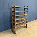 Old wooden workshop shelf with cast iron wheels.