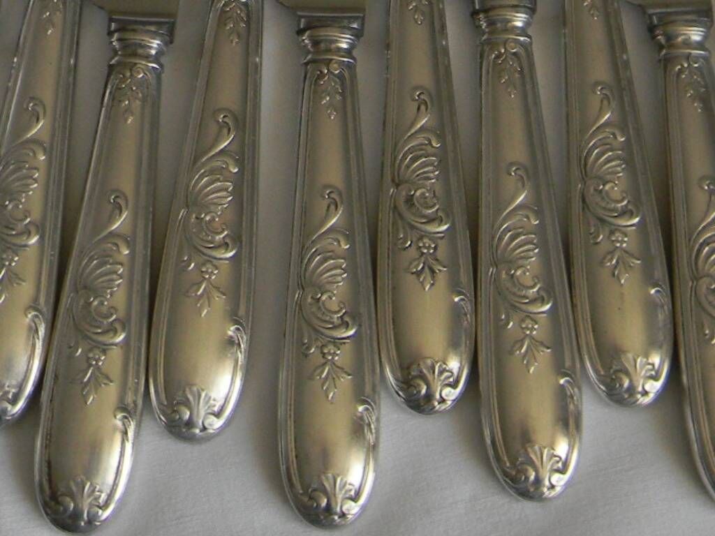 Set of 12 knives with silver metal handles and stainless steel blades.