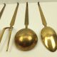 5 kitchen utensils and a brass wall mount