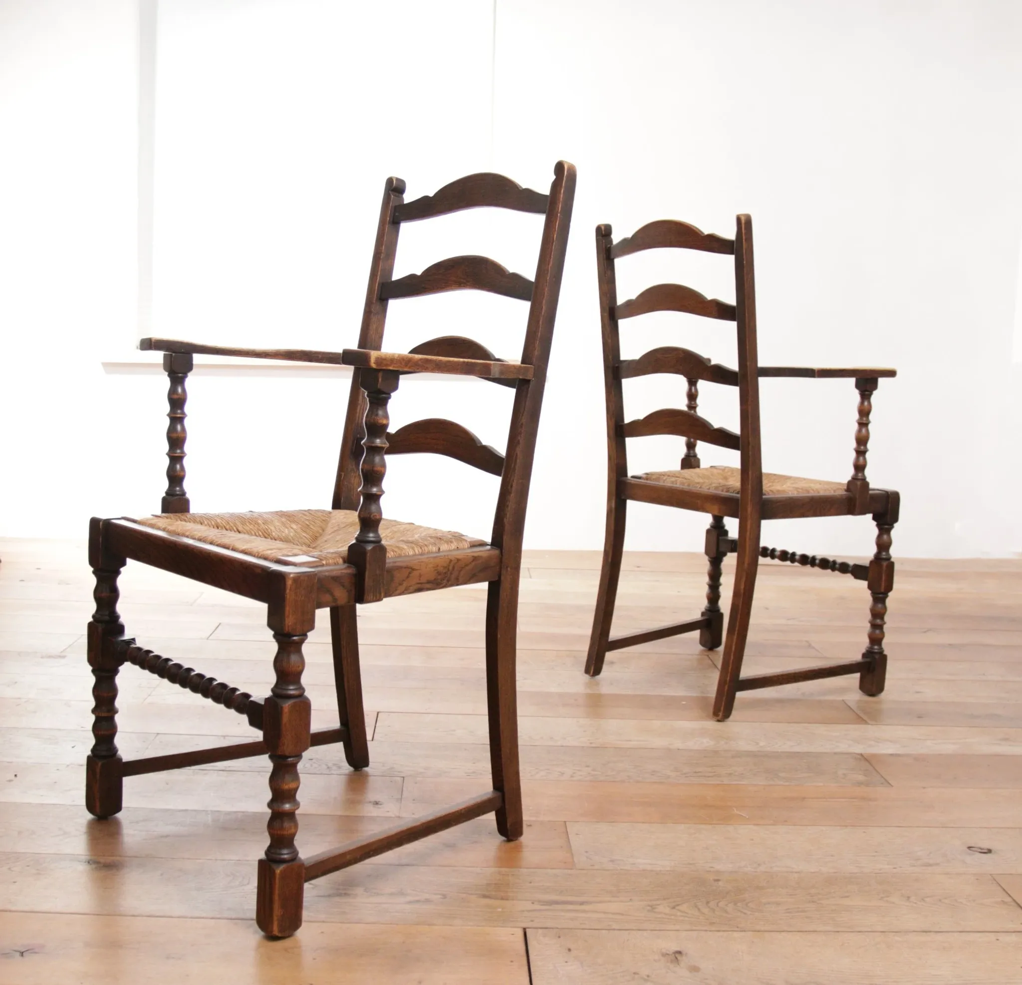 Pair of English oak armchairs with ladder back and rush seats