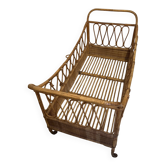 Vintage rattan baby cot on wheels.