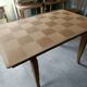 Oak dining table with a checkerboard top and extensions.