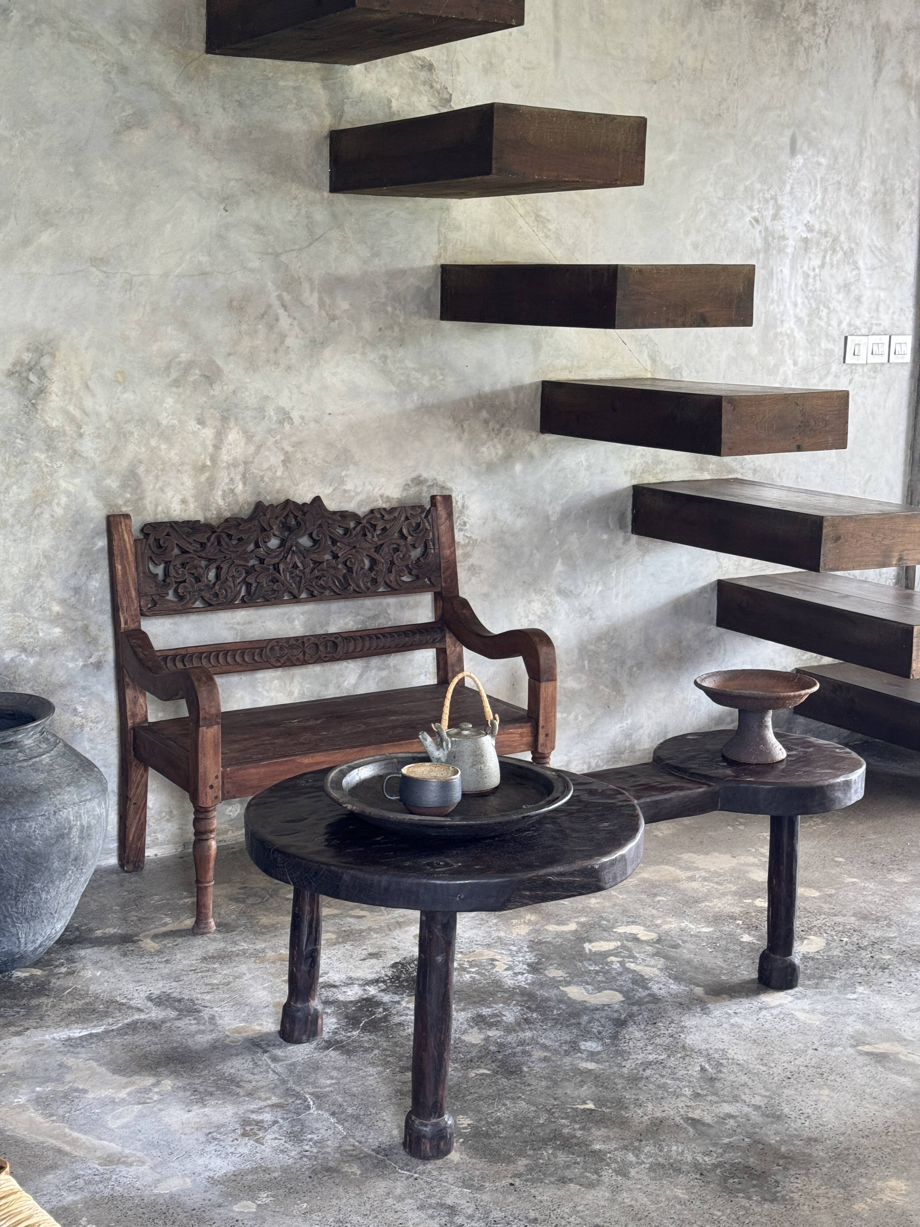 Small antique Indonesian bench in carved teak with plant and floral motifs.