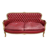 Louis XV style basket canapé with a curved back, upholstered in leather.