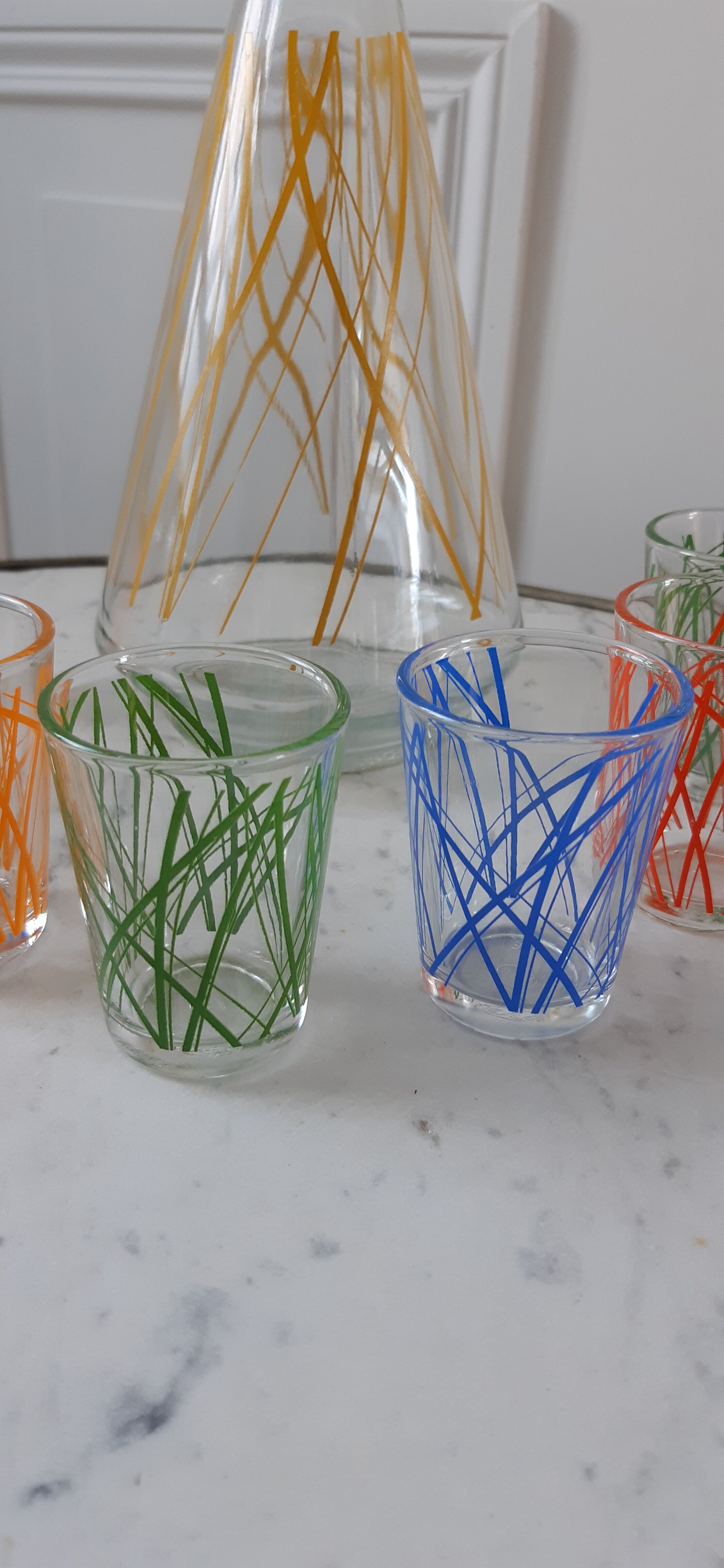 Colorful set consisting of a decanter and 7 70s liqueur glasses