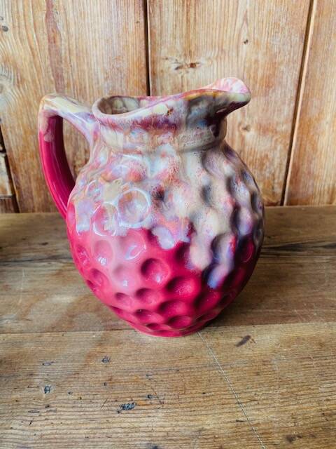 Old pitcher in burgundy ceramic