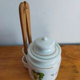 Vintage porcelain pickle pot with wooden pliers.