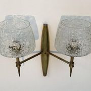 Pair of bronze wall sconces with worked glass reflectors. Stilnovo