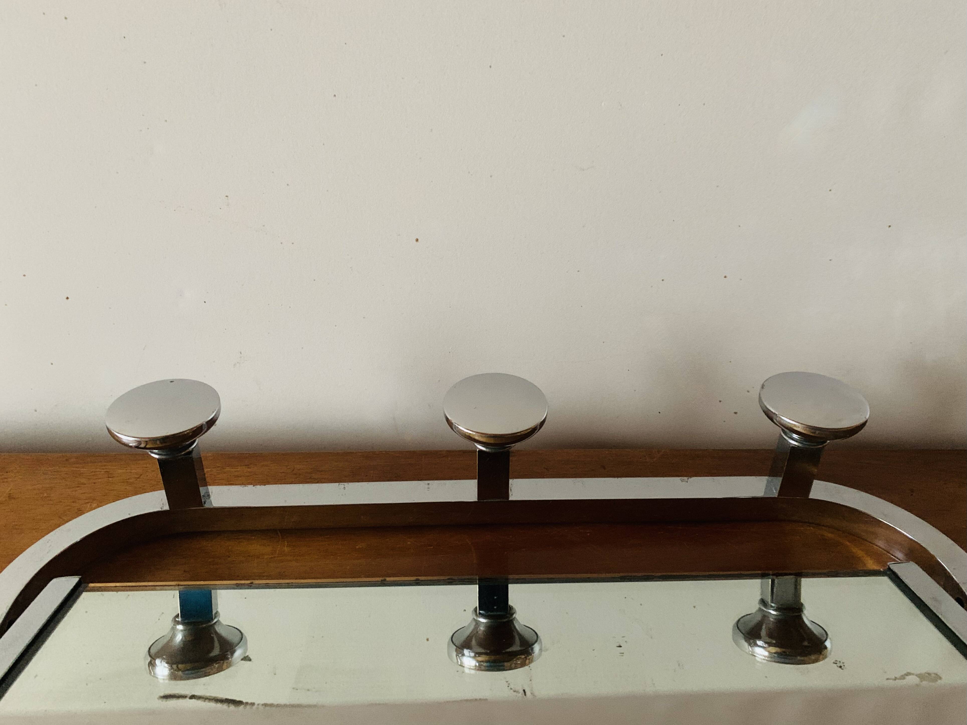 Vintage wall-mounted coat rack in chrome metal with integrated mirror and hat rack