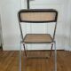 Vintage folding chair in metal and cane.