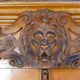 Antique carved wooden sideboard with several sculptures.