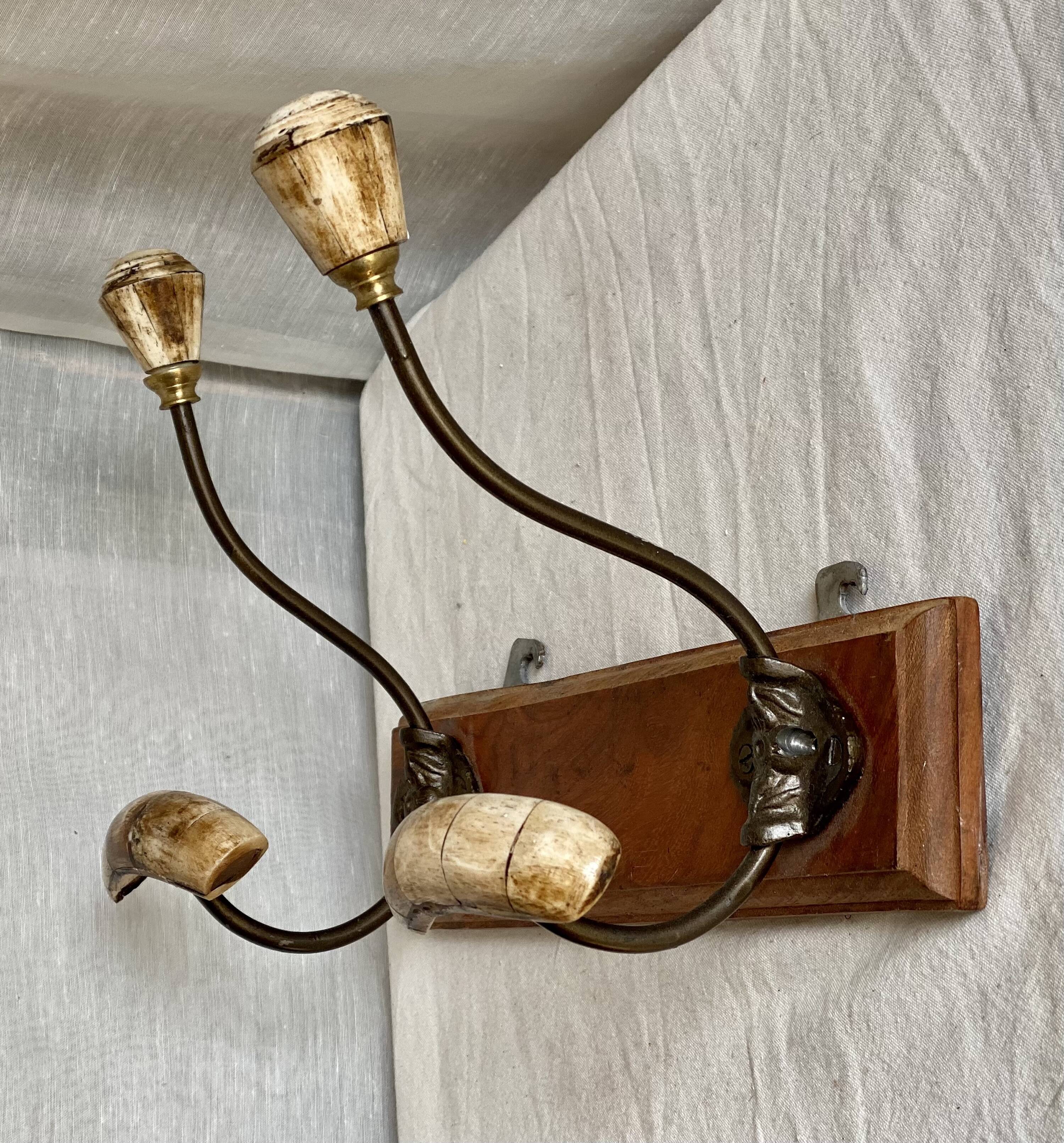 19th-century wall coat rack with 2 metal and horn hooks.