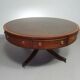 Table basse / table tambour victorienne « Heldense » en acajou avec plateau en cuir sur roulettes en laiton. Années 1980