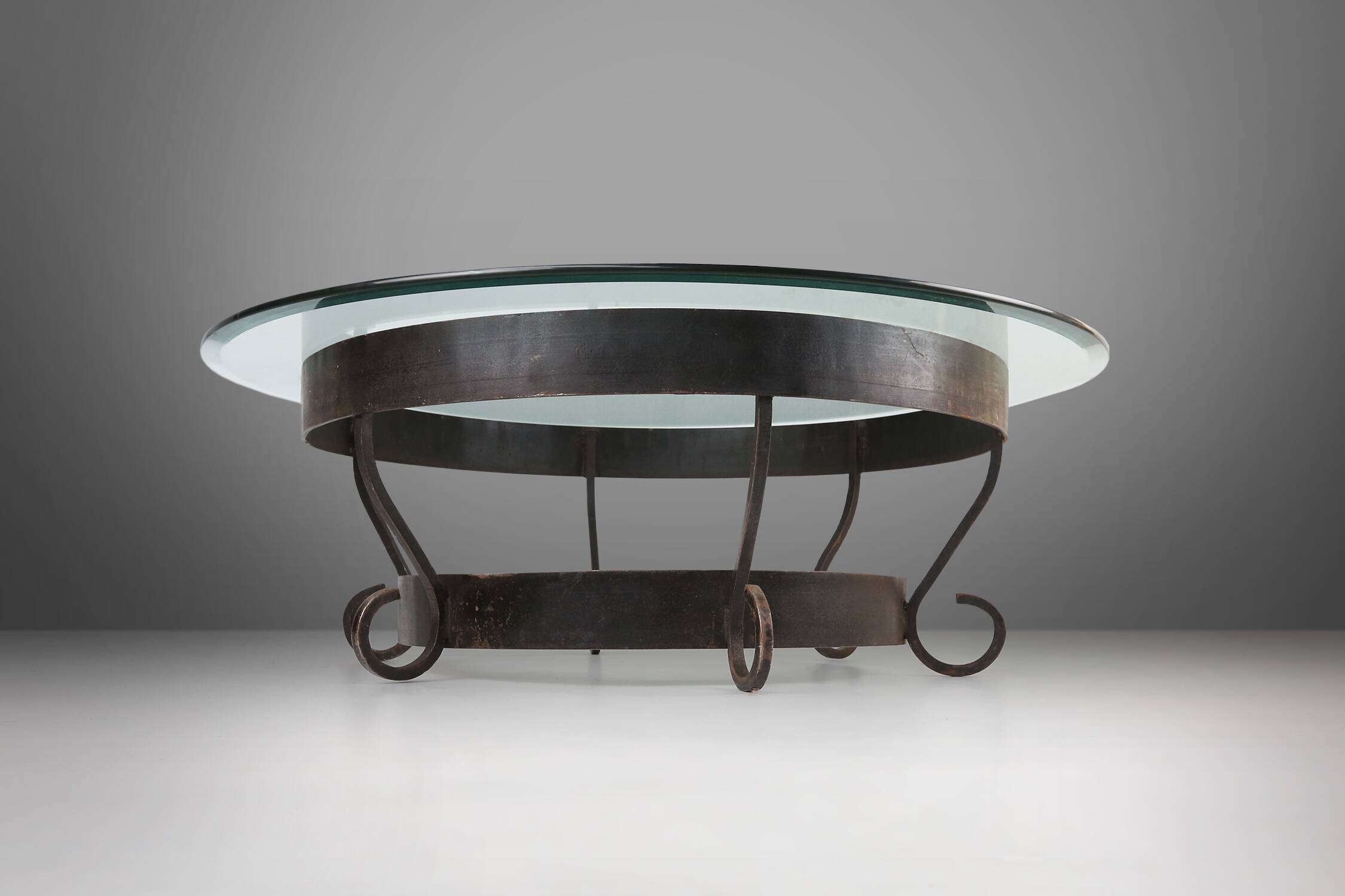 Rustic round coffee table with wrought iron base and glass top, France, 1930s