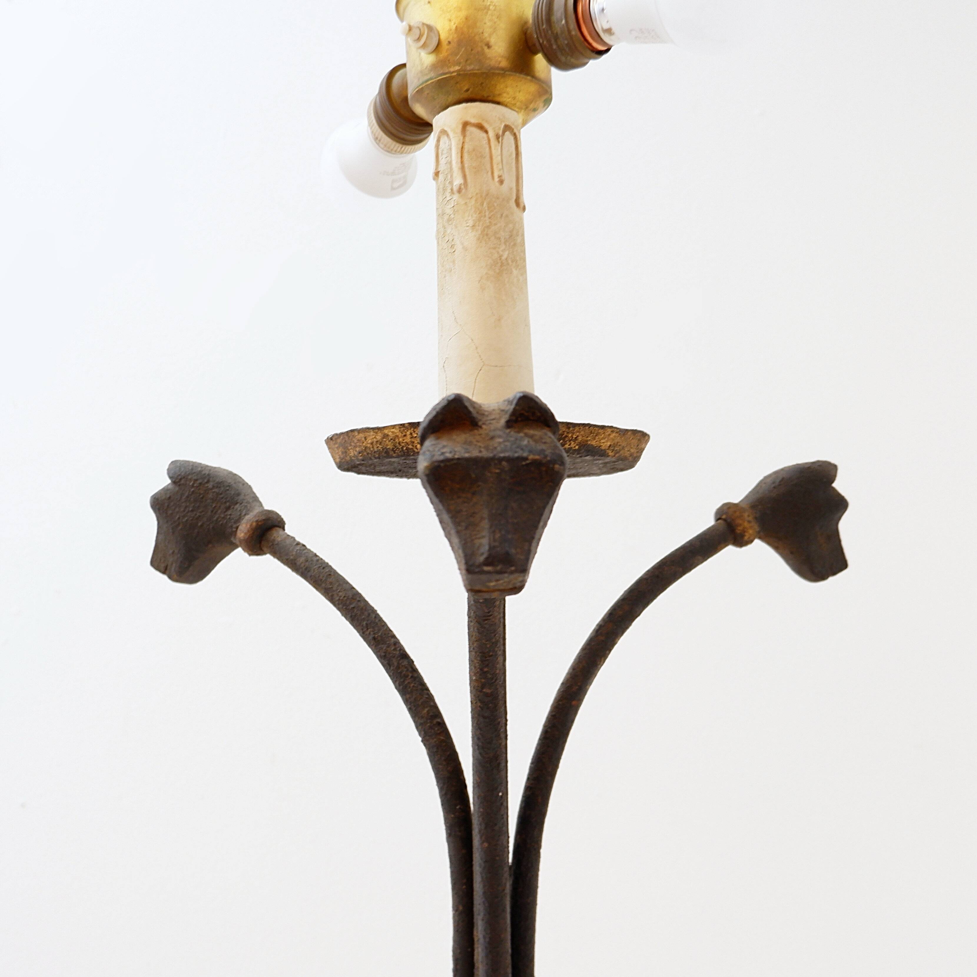 Wrought iron tripod floor lamp decorated with stylized animal heads