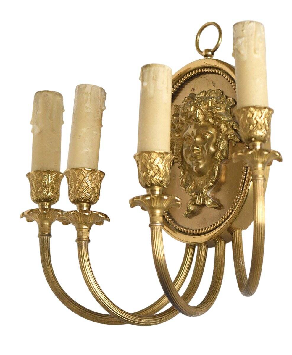 Pair of wall sconces with a relief decoration of a Bacchus mask.