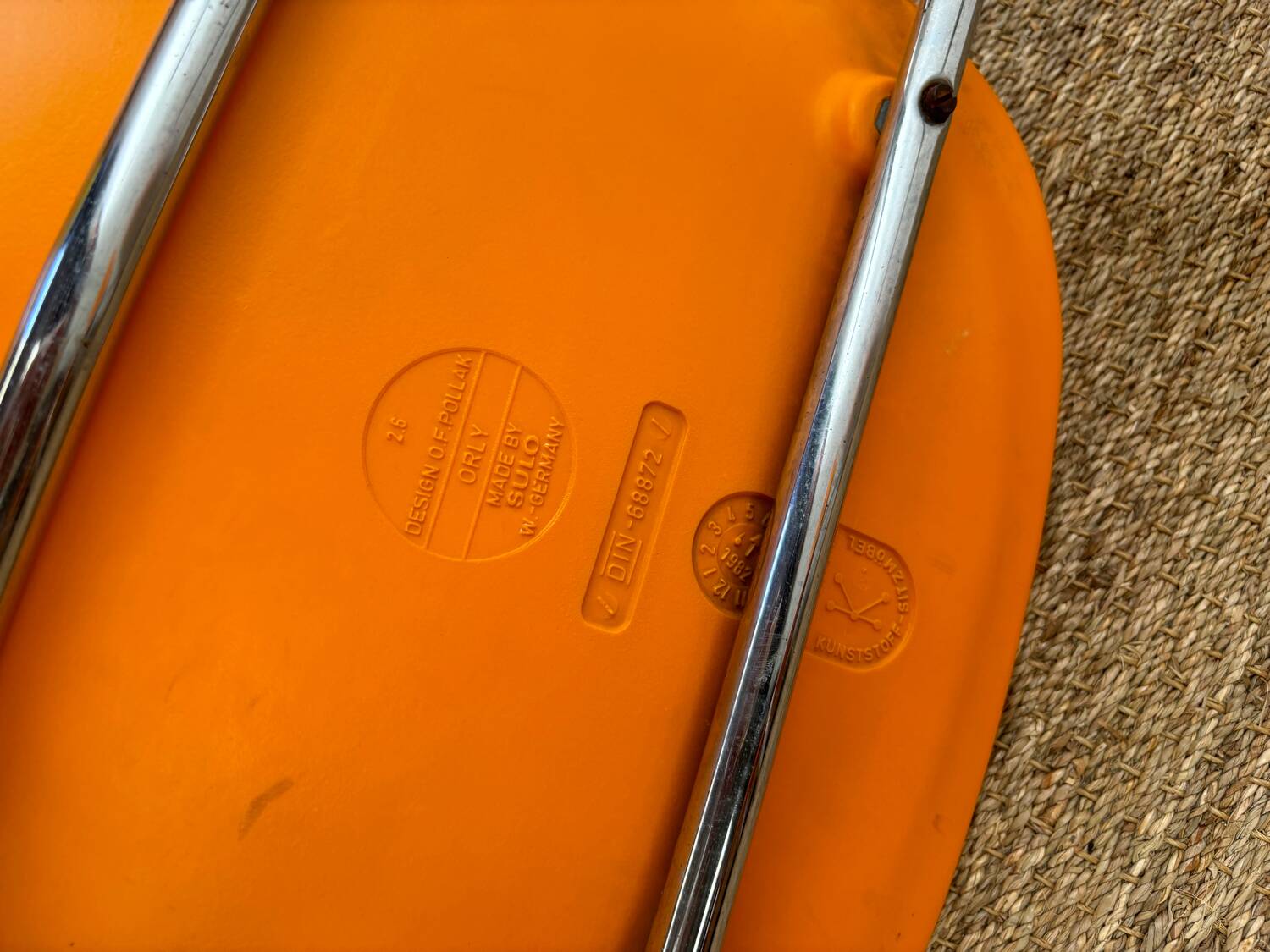 Two orange plastic pollak chairs at Orly airport