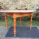 Table ovale ancienne en cerisier à piétement parapluie.