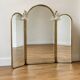 Vintage triptych mirror in brass with wall lights.