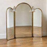 Vintage triptych mirror in brass with wall lights.